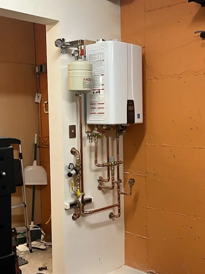 Plumbing technician inspecting water heater connections in Rocky River